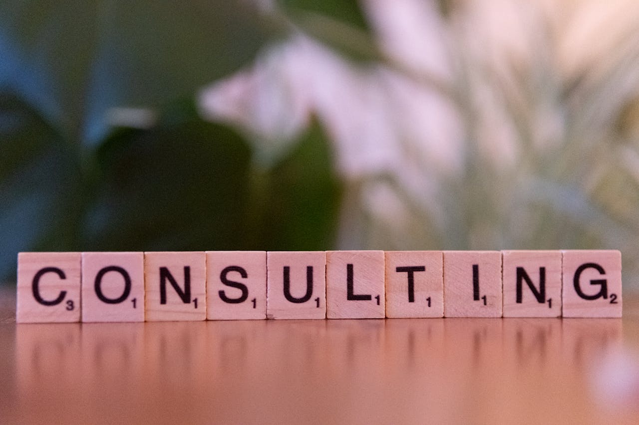 services-02 Wooden letter tiles spelling 'Consulting' with a blurred background. Ideal for business concepts.