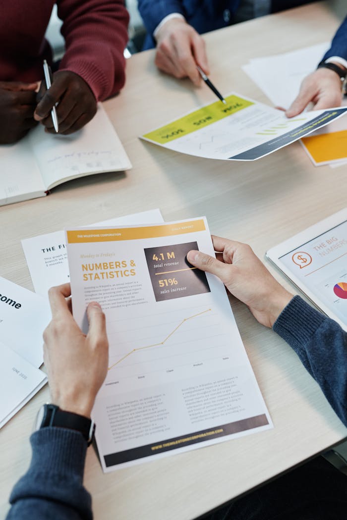 ours-journey A group reviews business statistics and reports on a wooden table.